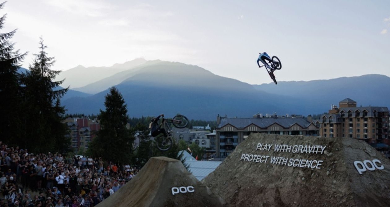 Slopestyle rider above a branded jump at Whistler